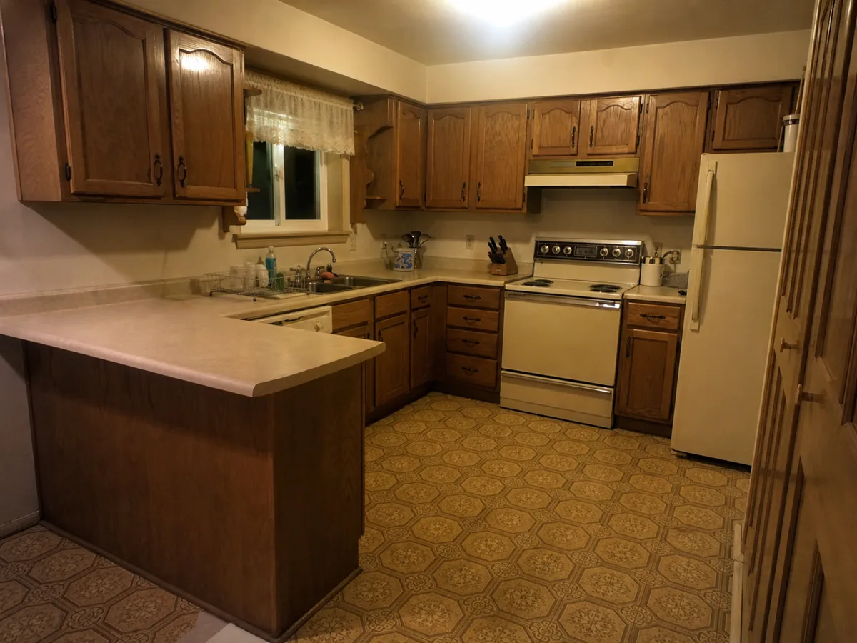Dated kitchen with worn oak cabinets before the remodel